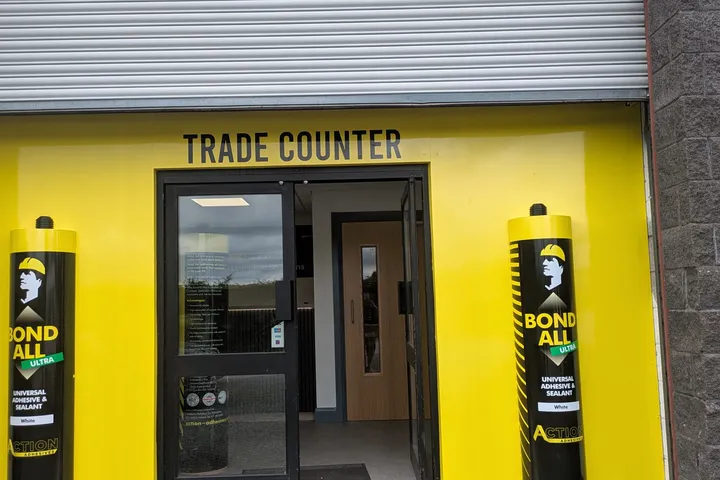 Action Adhesives trade counter shop front in bright yellow with two 5ft replica adhesive tubes flanking the entrance.