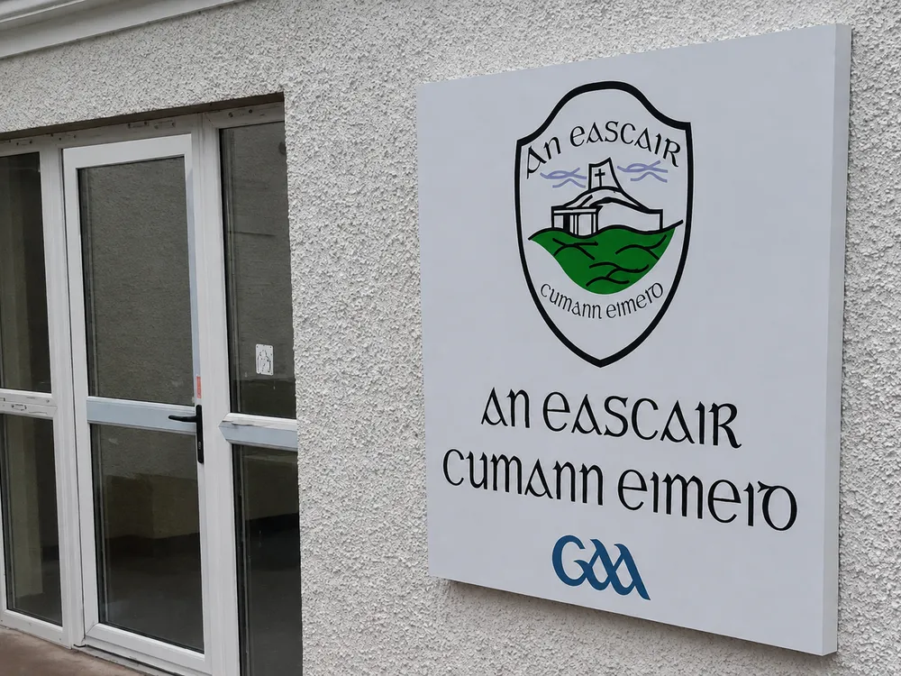 Eskra GAA composite aluminium club crest sign fixed to a rendered exterior wall.