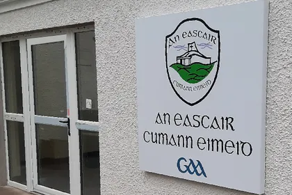 Eskra GAA composite aluminium club crest sign fixed to a rendered exterior wall.