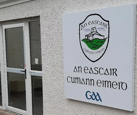 Eskra GAA composite aluminium club crest sign fixed to a rendered exterior wall.