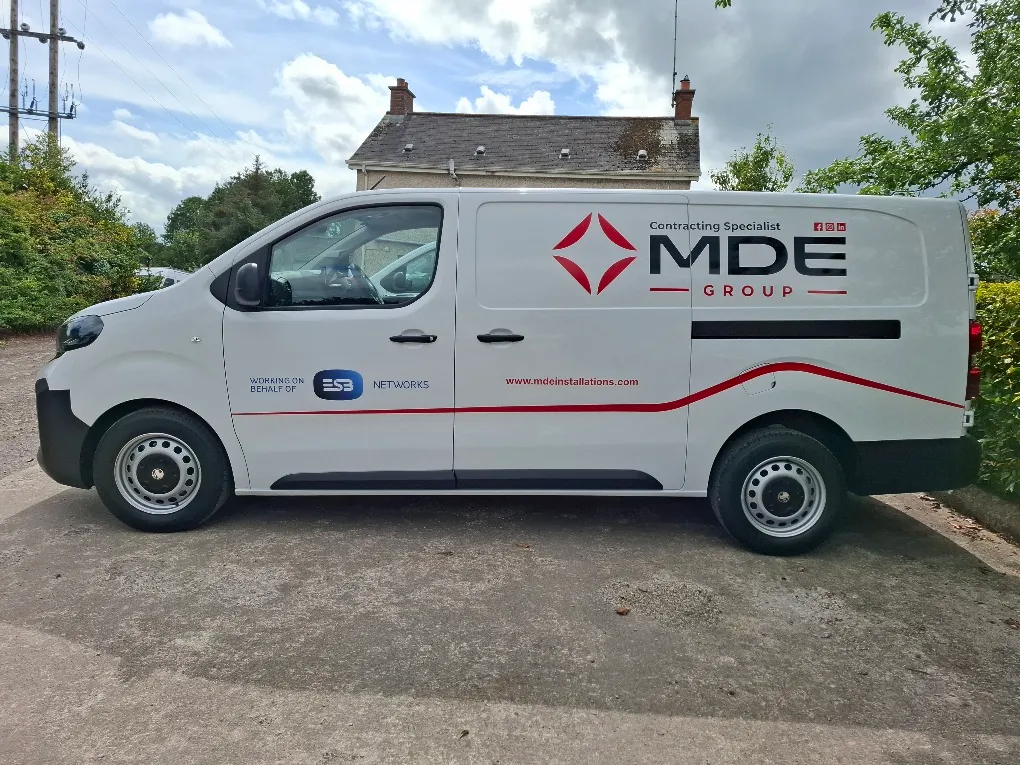 MDE Group Peugeot van in white livery with a black wordmark, red diamond icon and a red pinstripe along the side panel.