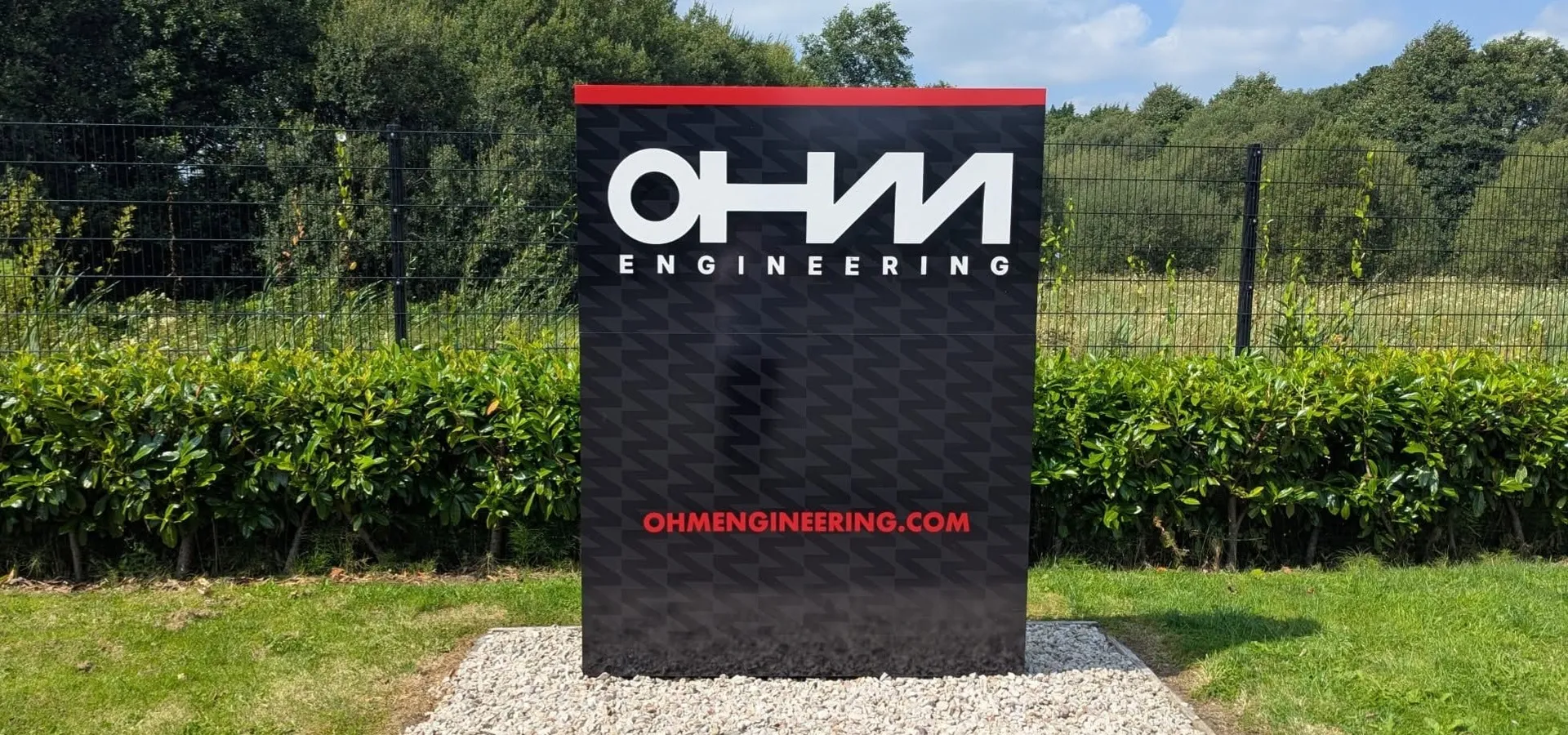 OHM Engineering freestanding illuminated totem sign at the entrance to their site.