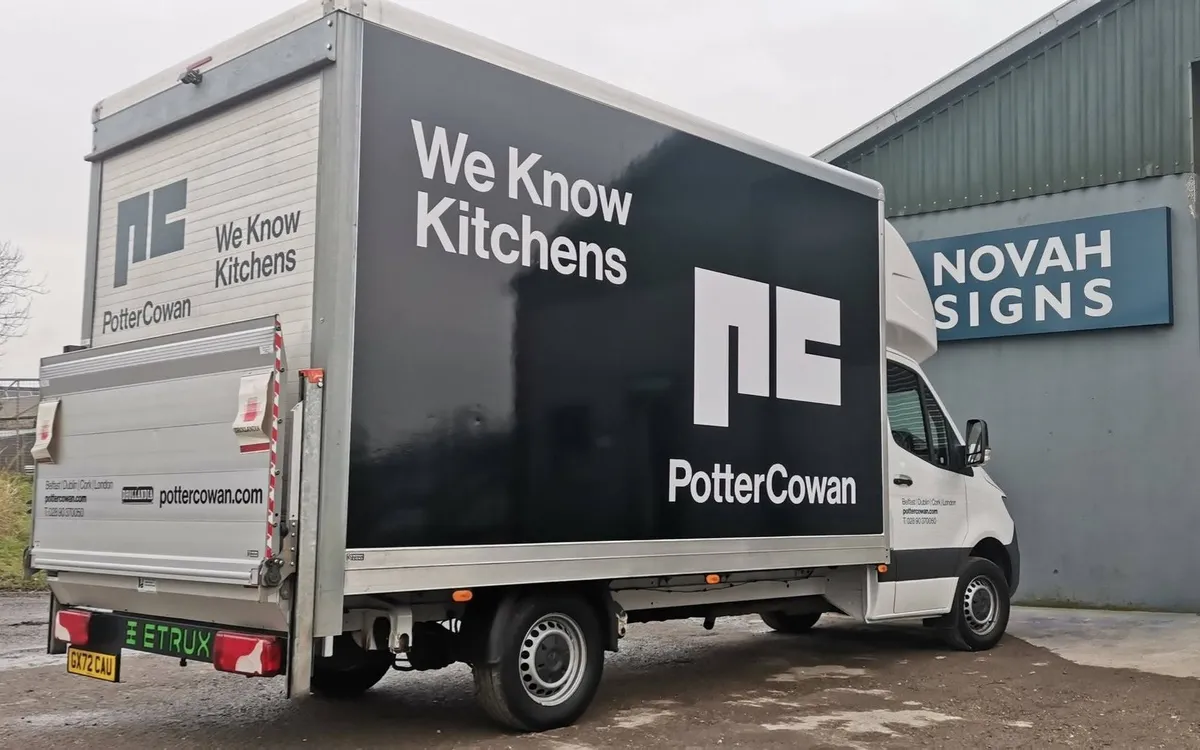 Potter Cowan box truck with a full vehicle wrap reading We Know Kitchens, photographed outside the Novah Signs workshop.