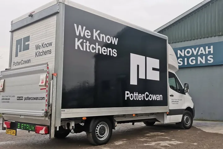 Potter Cowan box truck with a full vehicle wrap reading We Know Kitchens, photographed outside the Novah Signs workshop.